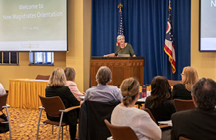 Image of Ohio Supreme Court Chief Justice Maureen O'Connor speaking to a roomful of men and women from behind a lecturn