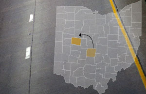 Image of a county map of ohio, with Franklin and Logan counties highlighted, superimposed over a highway