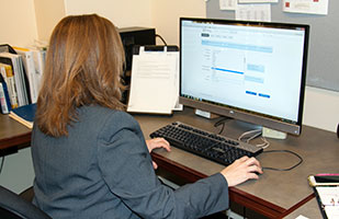 Image of a woman in a buisness suit using a computer