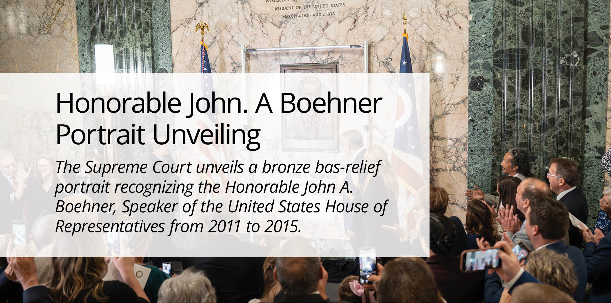 A crowd applauds a bronze plaque unveiling for John A. Boehner on a marble wall, flanked by U.S. and Ohio flags, conveying a celebratory mood.