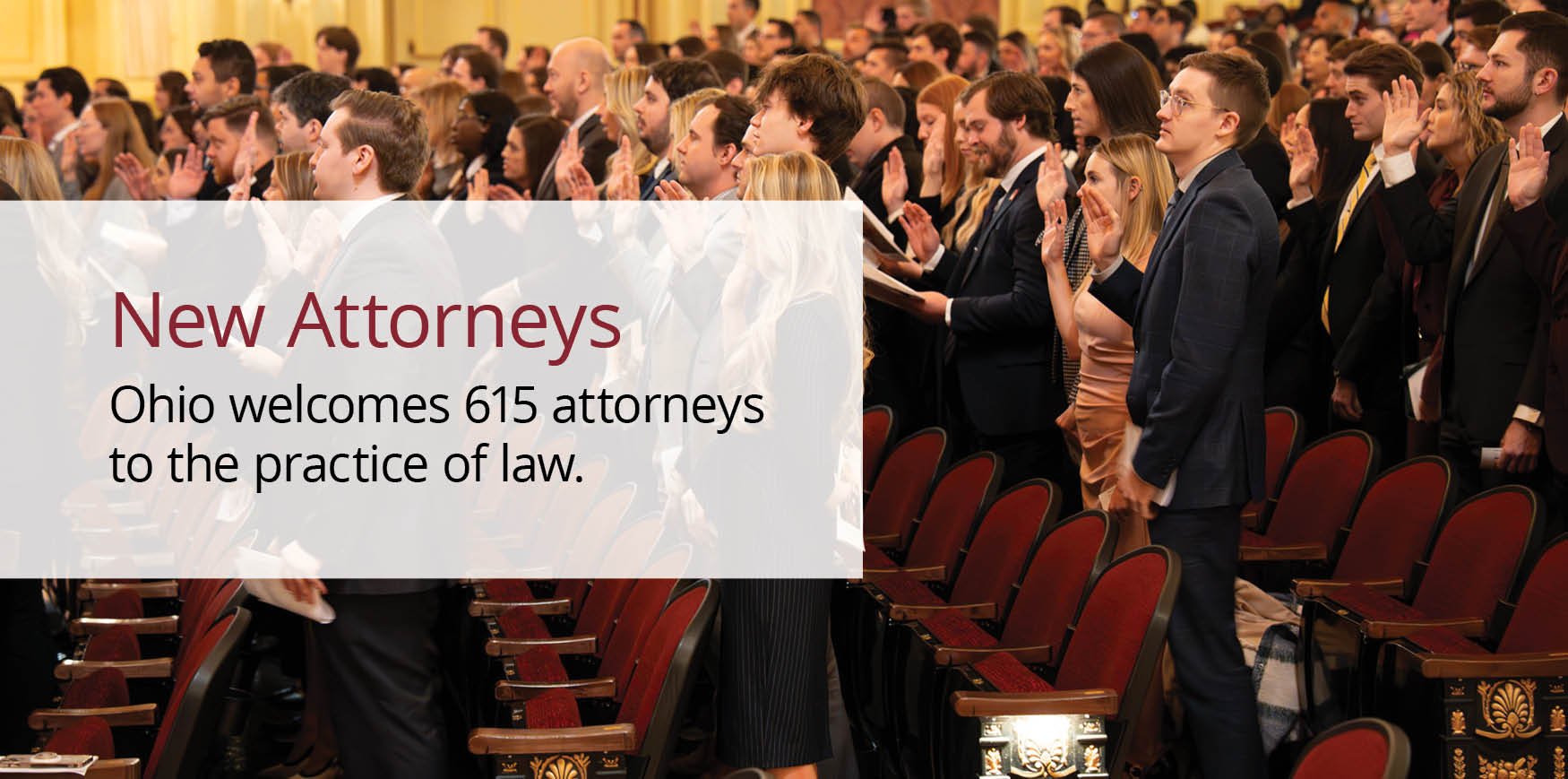 A large group standing holding their right hand in the air while reading from a book