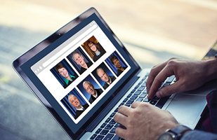 Image of a person using a laptop that has individual head shots of the Ohio Supreme Court Chief Justice and Justices pictured on it