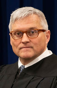 Image is a headshot of Judge Ronald C Lewis in his black judicial robe
