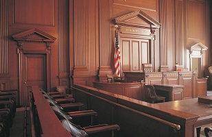 Image of a courtroom looking at the judge's bench from the jury box.