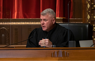 Image of a male judge wearing a black judicial robe in the courtroom of the Thomas J. Moyer Ohio Judicial Center