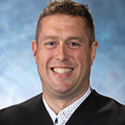 Image of a male judge wearing a black judicial robe.