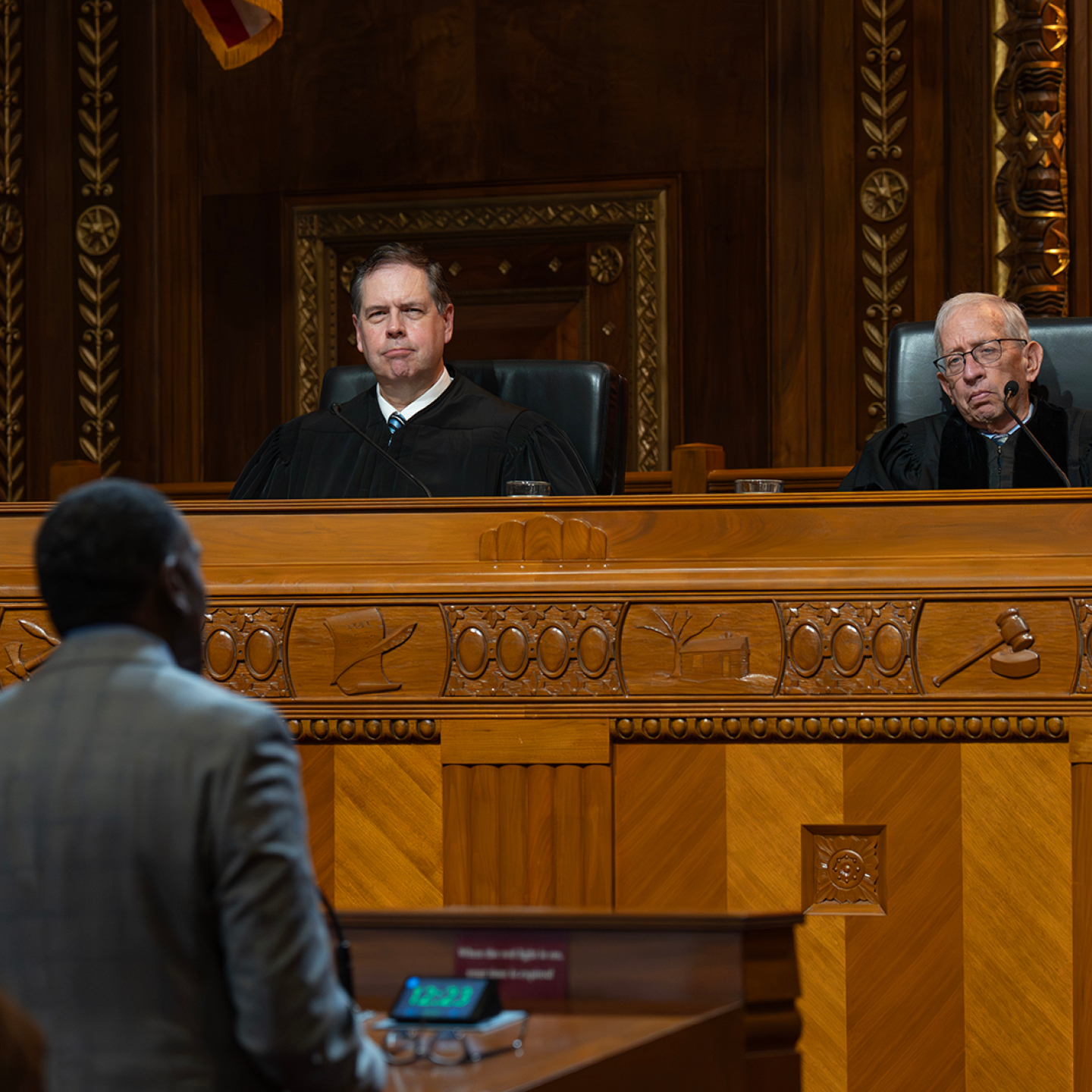 Male judge wearing a black judicial robe.