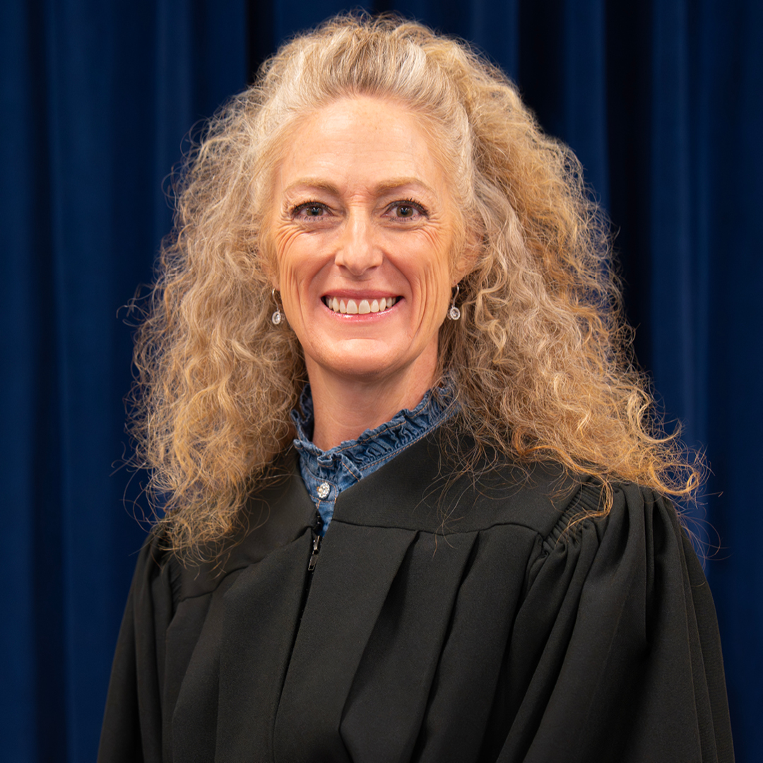 Female judge wearing a black judicial robe.