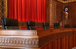 Image of Chief Justice Maureen O'Connor and justices Terrence O'Donnell and Sharon L. Kennedy listening to an attorney argue a case in the Ohio Supreme Court courtroom in the Thomas J. Moyer Ohio Judicial Center