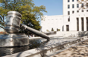 Image of the south plaza reflecting pool at the Thomas J. Moyer Ohio Judicial Center containing a large, steel sculpture of a gavel