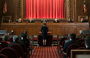 Image of a female attorney presenting oral arguments before the Chier Justice and Justices of the Supreme Court of Ohio in the courtroom of the Thomas J. Moyer Ohio Judicial Center