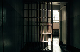 Image of an open jail cell door (Thinkstock)