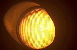 Image of a close-up view of the illuminated yellow light in a traffic signal (edwardolive/THINKSTOCK)