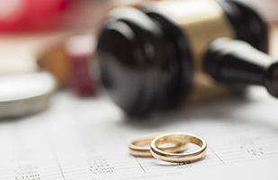Image of a pair of gold wedding bands sitting by a judge's gavel