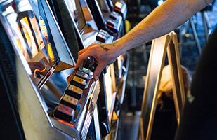 Image of a man playing a slot maching