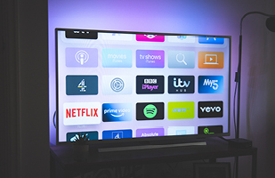 Image of a tv screen showing the logos of different streaming apps, including Netflix