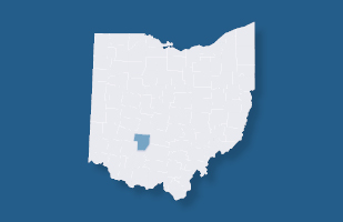 Image of a light grey Ohio county map with one county colored in blue. The entire map is resting on a blue background.