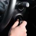 Person with their hand on a car ignition