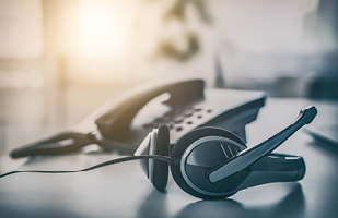 Image of a telephone headset next to a telephone.