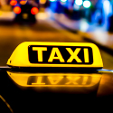 Image of an illuminated taxi sign on the roof of a taxi.