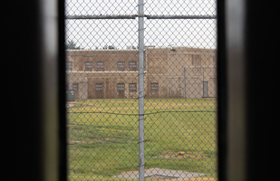 A prison yard as seen through a chain link fence.