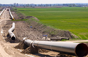 Image showing large, metal pipes lying on dirt.