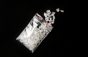 Image of a small, clear, plastic bag filled with white crystals.