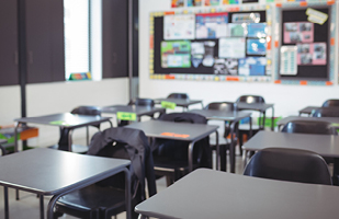 Image showing the inside of a classroom with rows of empty student desks.