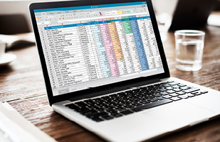 An open laptop showing a colorful spreadsheet on the screen.