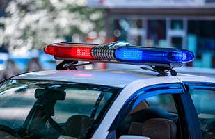 Image of the red and blue flashing lights on the roof of a police cruiser.