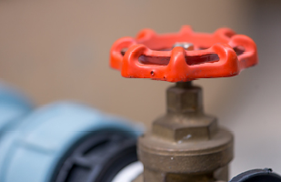 Image of an orange pipe valve handle.