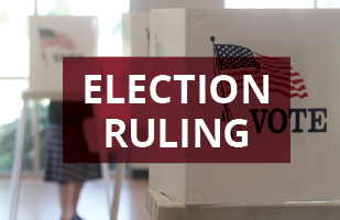 Image of a privacy barrier with an American flag and the words 'I Vote' at an election polling location.