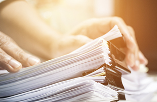 Multiple stacks of paper bound with large paper clips.