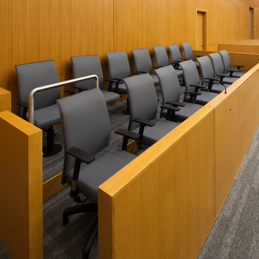 Two rows of empty chairs in a jury box.