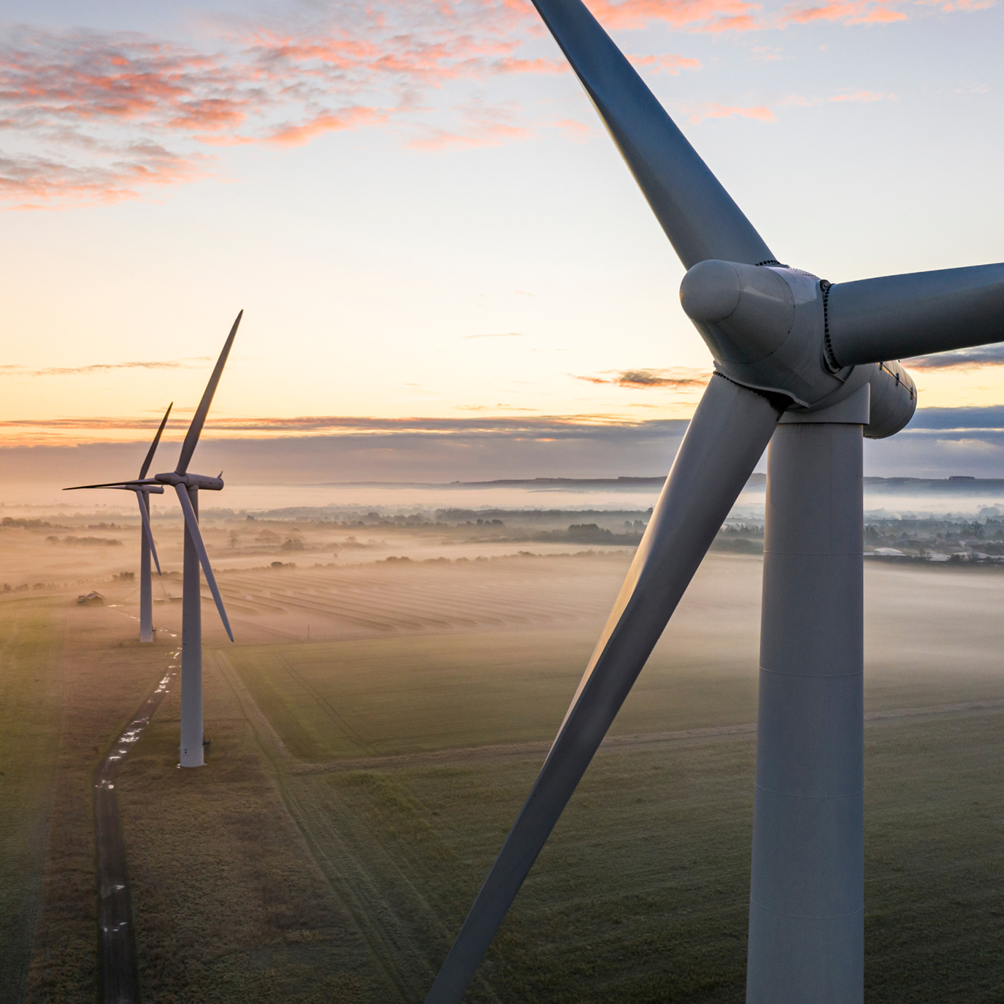 An aerial, close-up view of a large white wind turbine.