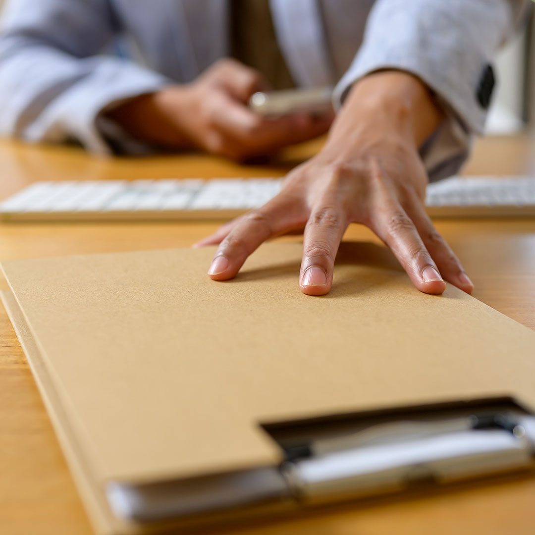 A man's hand reaching for a folder