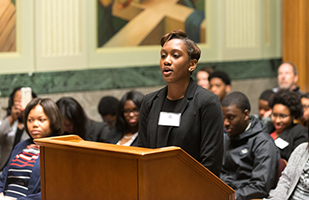 Image of a student standing at a podium completing in the Law and Leadership Institute's 2016 Academic Year Competition.