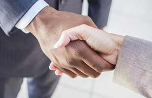 Image of two men in suits shaking hands (Thinkstock)