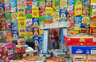 Image of Barberton Judges Todd McKenny and David Fish peeking out amidst hundreds of stacked cereal boxes