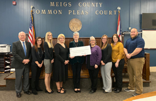 Image of Chief Justice Maureen O'Connor holding a large ceremonial check in the middle of 8 other court officials