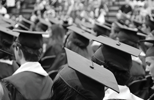 Image of a group of college graduates wearing caps and gowns