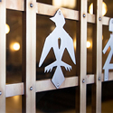 Close-up of a bronze door decorated with a silver cutout in the shape of a bird.