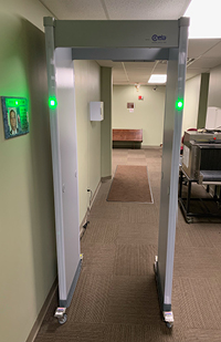 A metal detector with flashing green lights.
