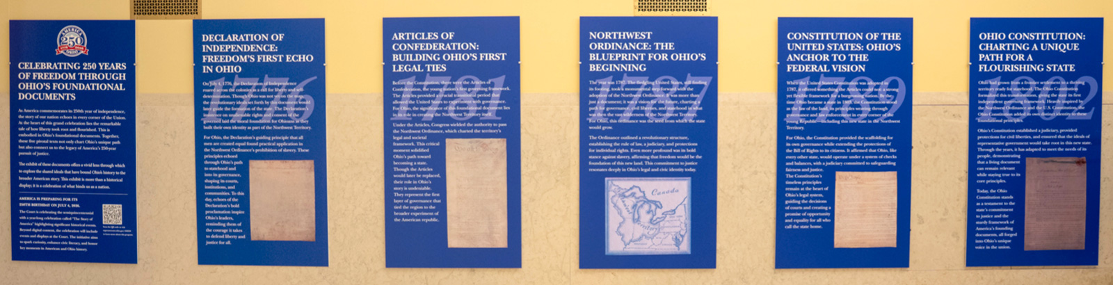 six plaques in a museum with history facts about America and highlighting America's 250th birthday