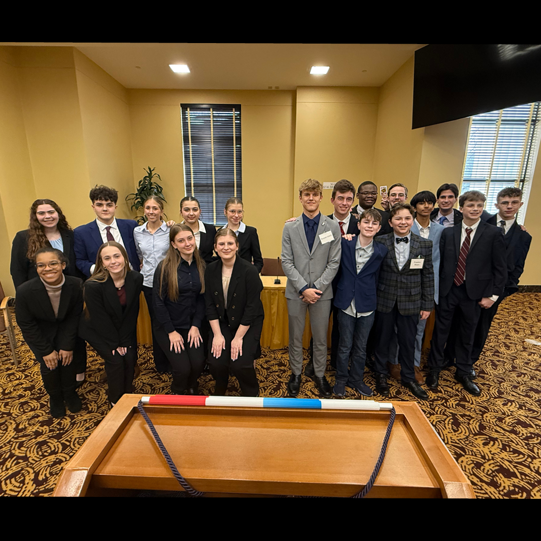 A group standing in a circle with their hands stacked on each other