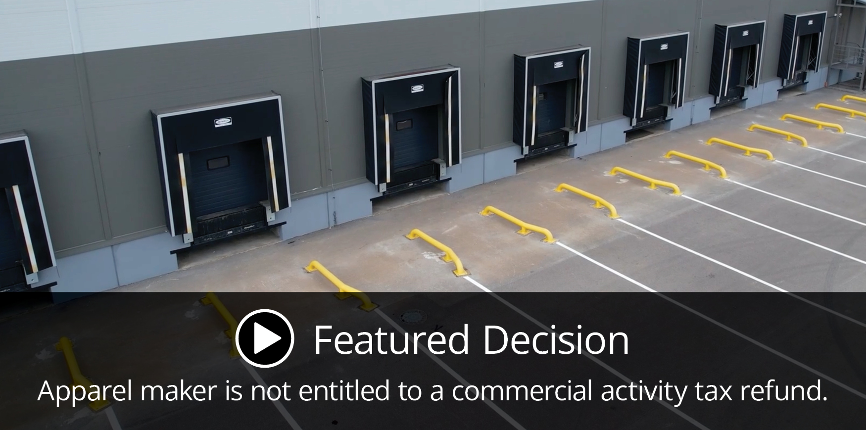 An industrial loading dock with multiple closed bay doors. Text overlay reads, 'Featured Decision: Apparel maker is not entitled to a commercial activity tax refund.'